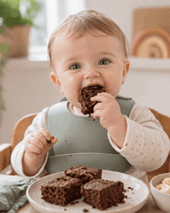 Baby-Schokokuchen ohne Zucker – perfekt für kleine Naschkatzen lächelndes Baby genießt schokoladen Kuchen